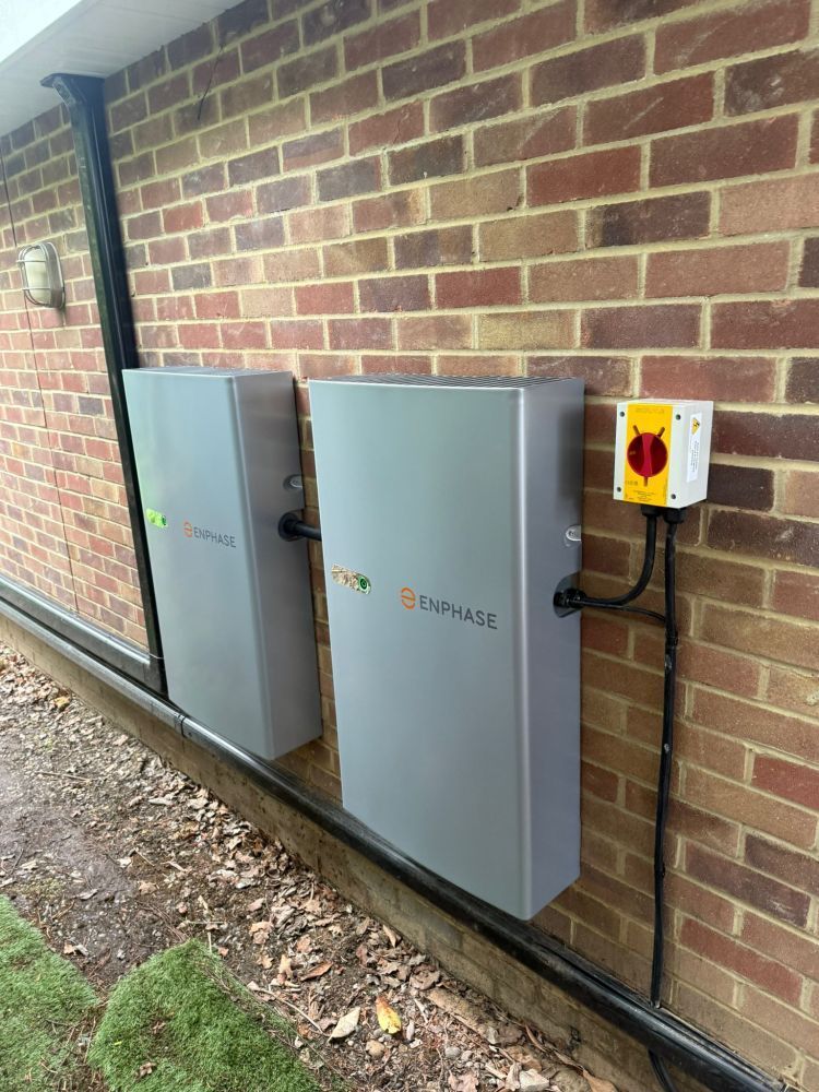 Two wall-mounted home battery units installed on a brick wall