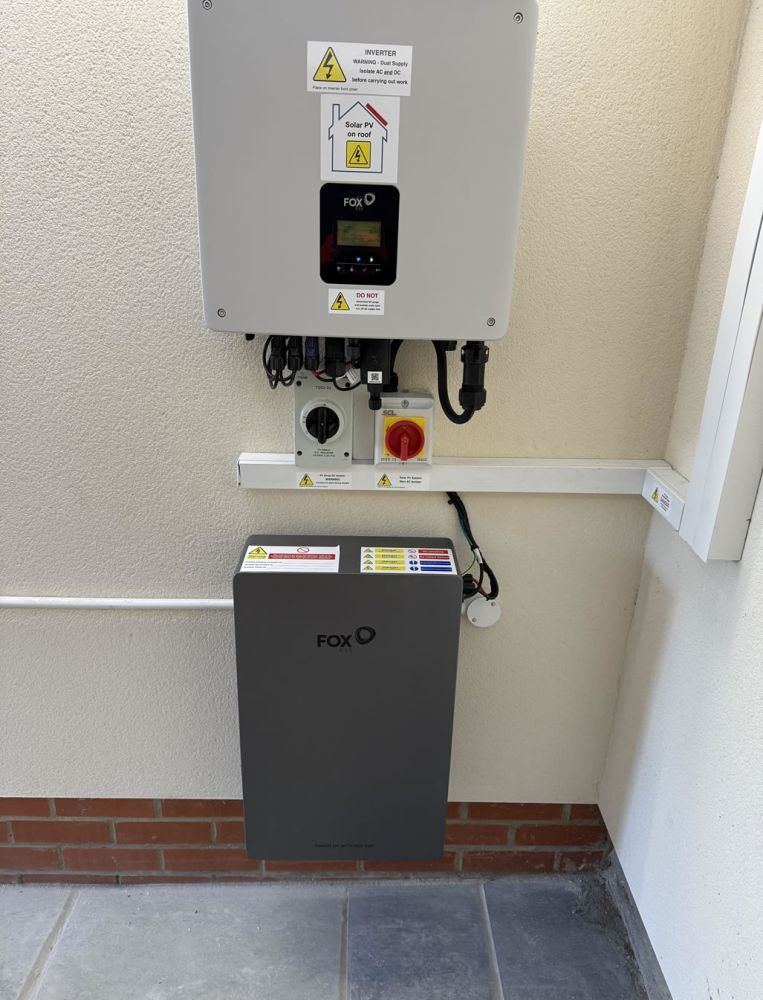 Neatly installed solar inverter and battery on a house wall