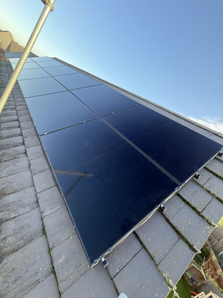 Large all-black solar array on a slate roof